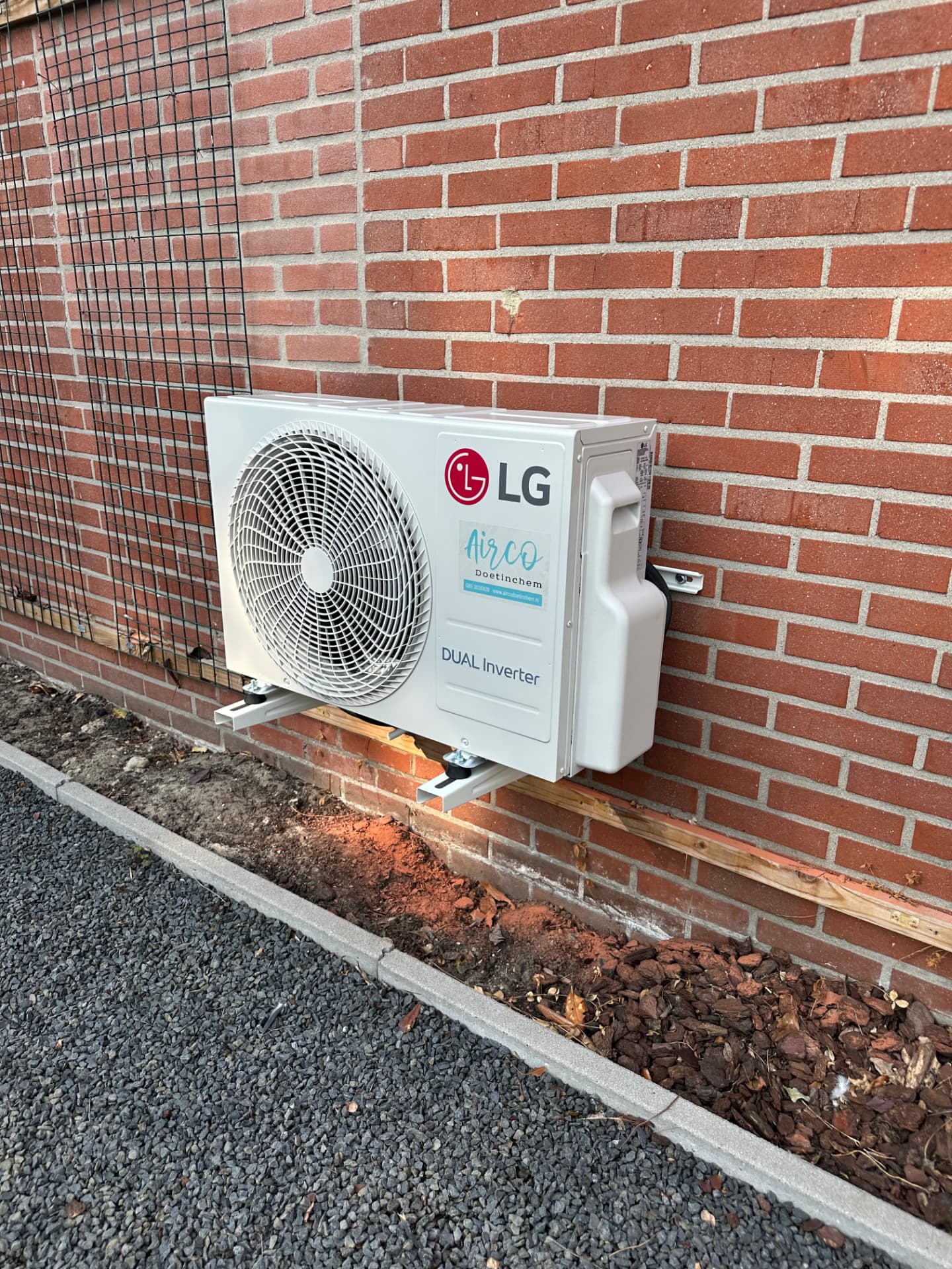 LG DUAL Inverter buitenunit op consoles aan een bakstenen gevel