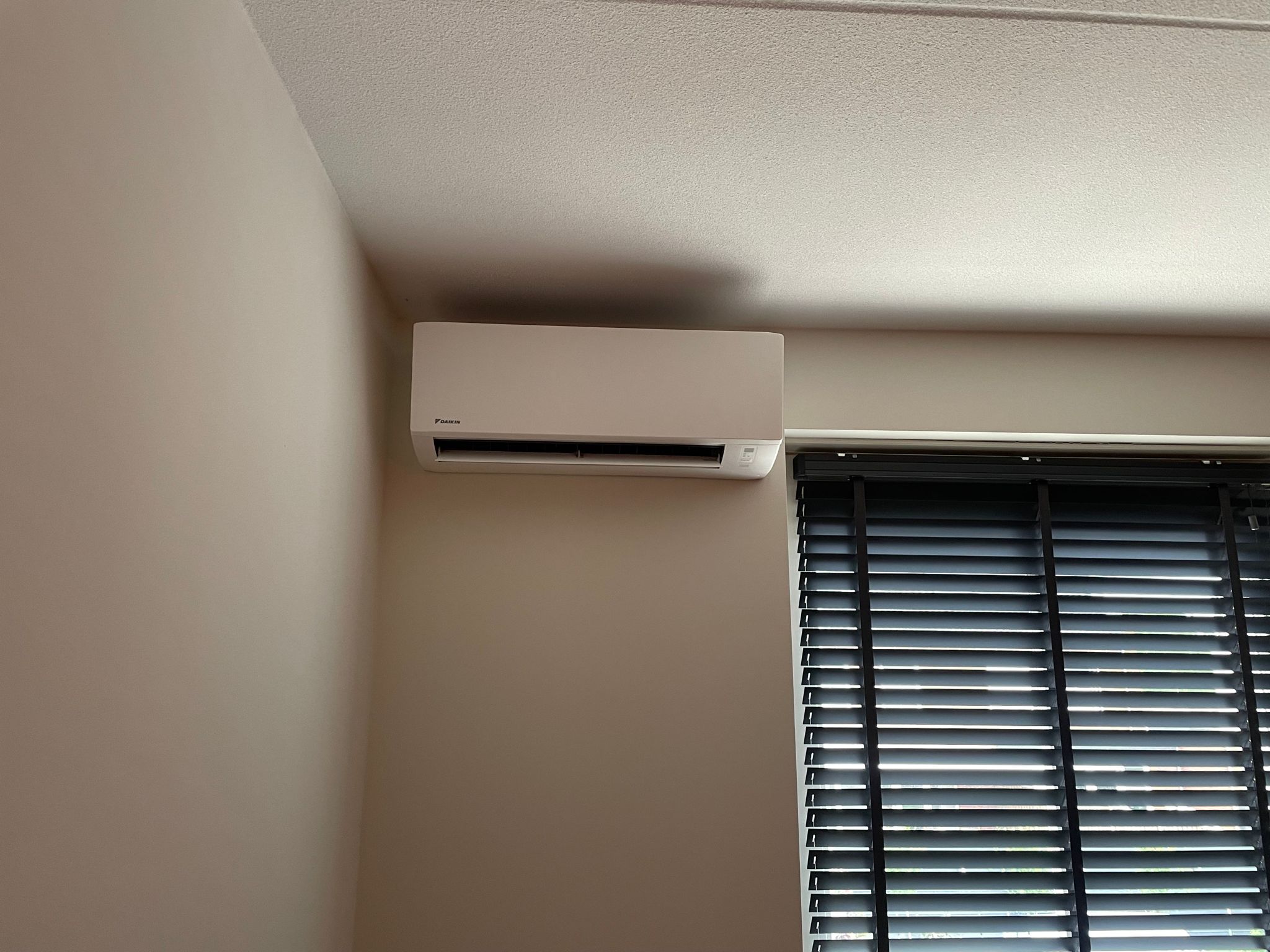 Witte binnenunit boven het raam