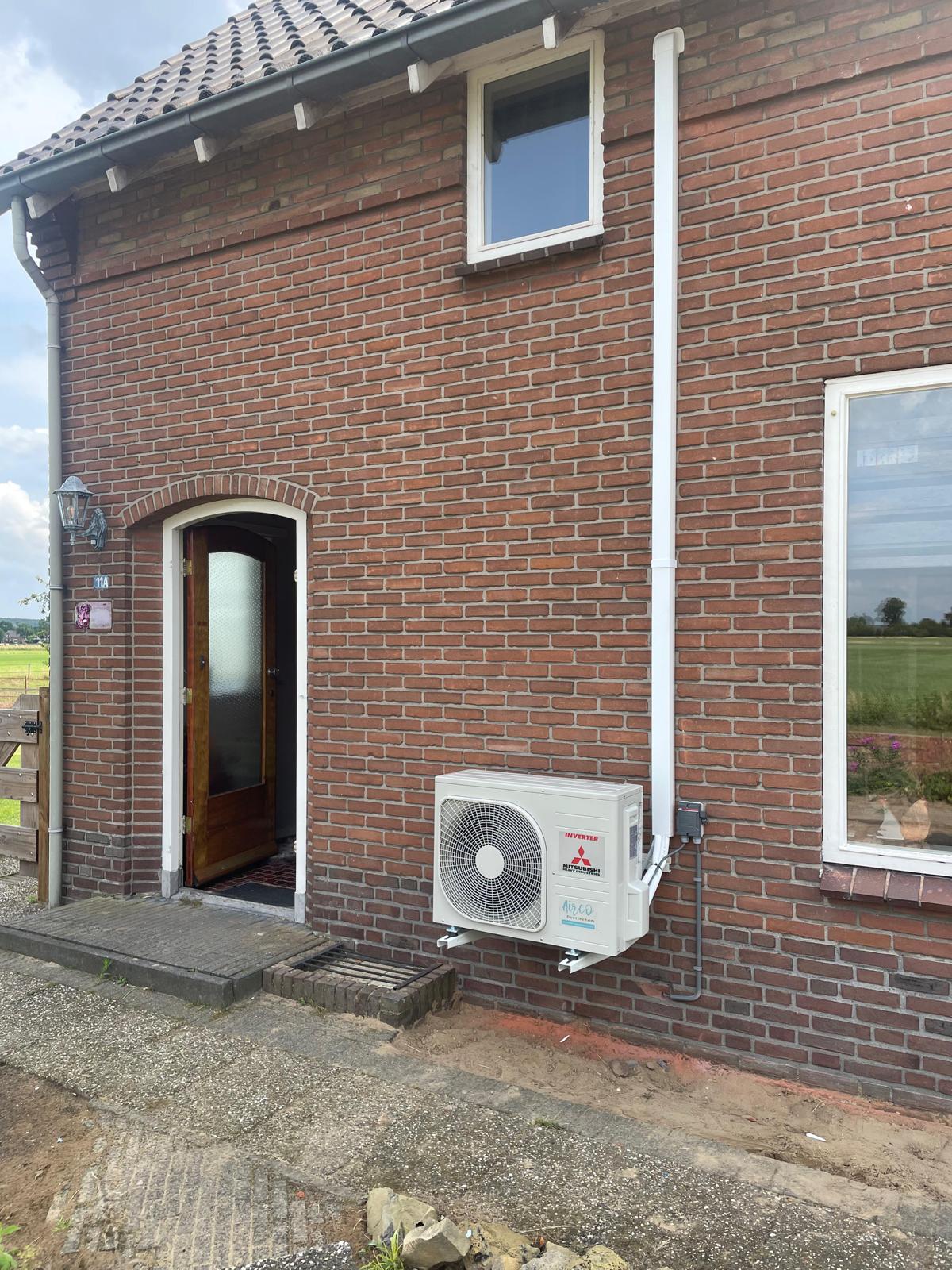 Buitenunit op consoles aan een bakstenen woning