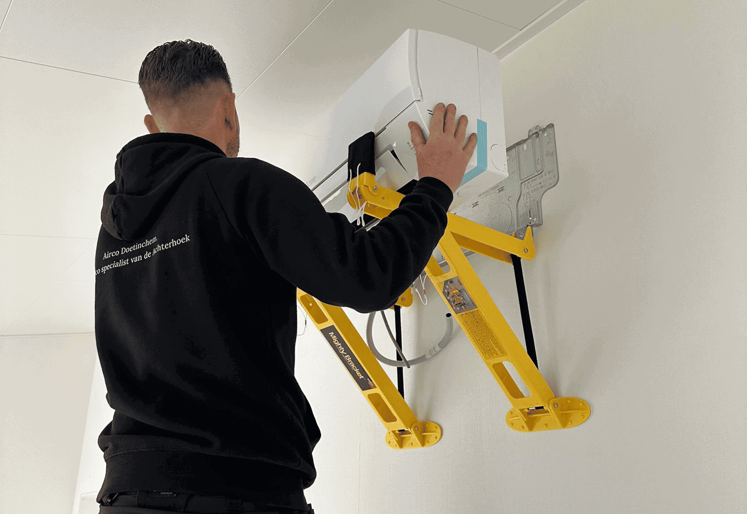Airco installateur monteert een airco aan de muur